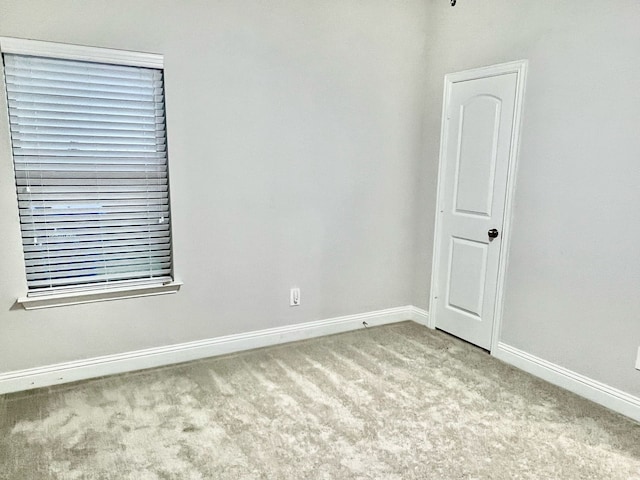 spare room with baseboards and carpet flooring