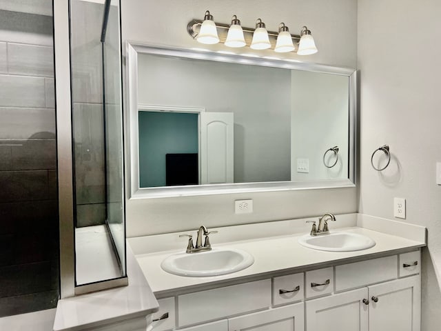 bathroom featuring a shower stall, double vanity, and a sink