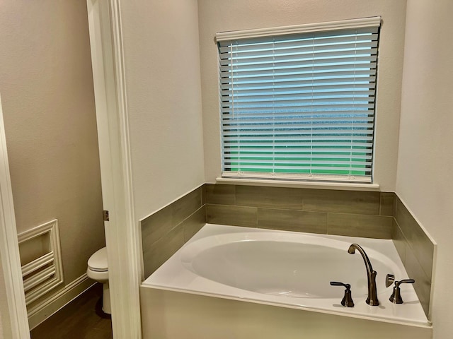 full bath featuring toilet and a bath