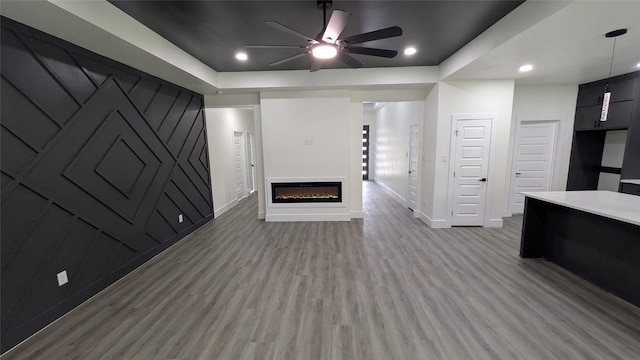 5629 Lester Granger, Fort Worth, TX 76112 - unfurnished living room with wood finished floors, a ceiling fan, baseboards, a glass covered fireplace, and recessed lighting