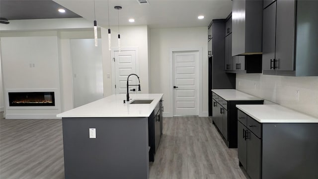 5629 Lester Granger, Fort Worth, TX 76112 - kitchen featuring a sink, a center island with sink, light wood-style floors, recessed lighting, and light countertops