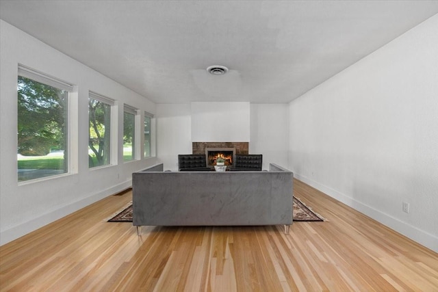 3848 S Drive, Fort Worth, TX 76109 - living room featuring a multi sided fireplace, light wood-type flooring, healthy amount of natural light, and baseboards