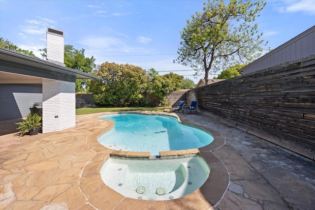 view of swimming pool with a patio, a pool with connected hot tub, and a fenced backyard