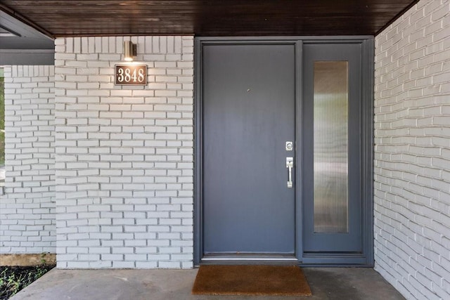 view of exterior entry with brick siding