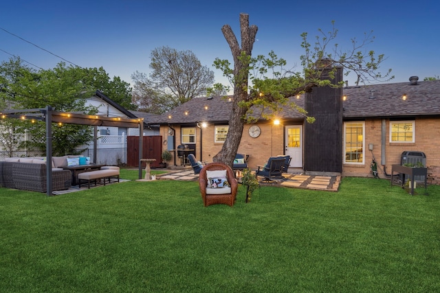back of house featuring a yard, brick siding, fence, a patio area, and outdoor lounge area