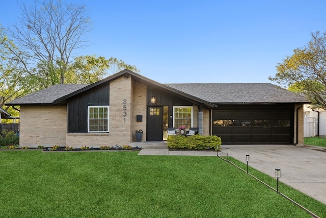 mid-century inspired home featuring driveway, a shingled roof, an attached garage, brick siding, and a front lawn