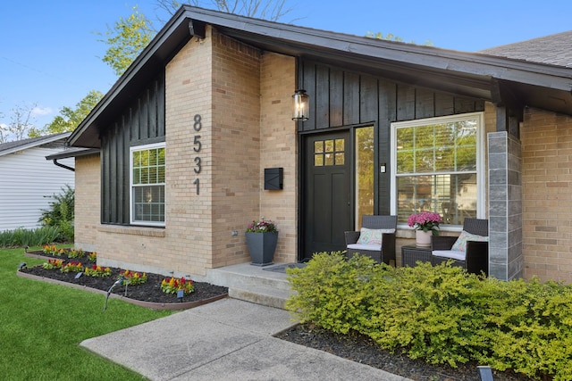 doorway to property featuring brick siding and board and batten siding