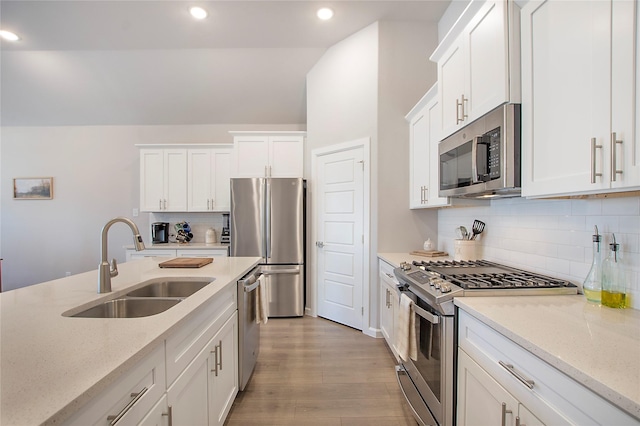 3908 Rochelle St, Celina, TX 75009 - kitchen with appliances with stainless steel finishes, light wood-style flooring, white cabinetry, backsplash, and recessed lighting