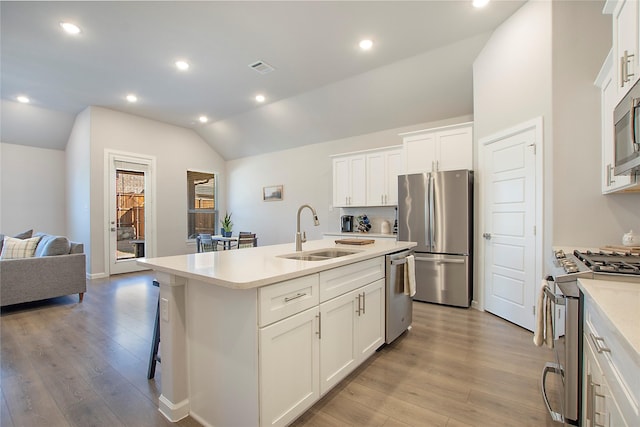 3908 Rochelle St, Celina, TX 75009 - kitchen featuring stainless steel appliances, vaulted ceiling, light wood-style flooring, a center island with sink, and light countertops