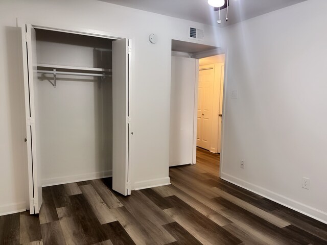 13633 Weald Green St, Dallas, TX 75240 - unfurnished bedroom with dark wood-style flooring, a closet, and baseboards