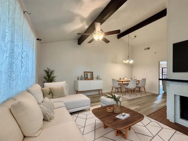 13633 Weald Green St, Dallas, TX 75240 - living room featuring light wood finished floors, ceiling fan, a chandelier, and a fireplace