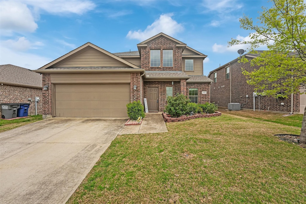 view of front facade with a front yard, central AC, a garage, brick siding, and driveway