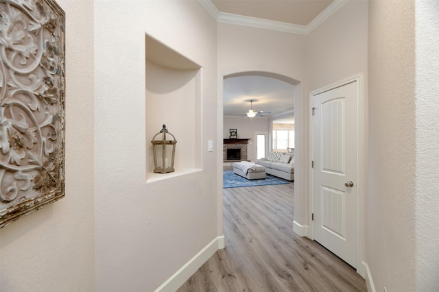 1664 Laramie Ln, Burleson, TX 76028 - hallway with crown molding, light wood finished floors, baseboards, and arched walkways