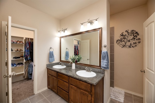 1664 Laramie Ln, Burleson, TX 76028 - bathroom featuring a sink, tile patterned flooring, and a walk in closet