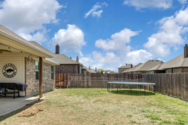 1664 Laramie Ln, Burleson, TX 76028 - view of yard featuring a trampoline, a fenced backyard, and a patio area
