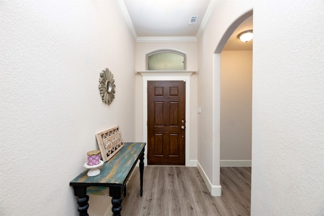 1664 Laramie Ln, Burleson, TX 76028 - entryway featuring visible vents, baseboards, arched walkways, ornamental molding, and light wood-style flooring