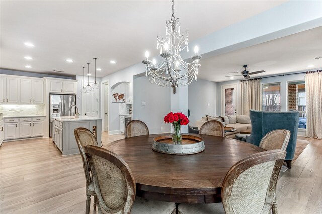 dining area with ceiling fan with notable chandelier, light wood-style flooring, baseboards, visible vents, and recessed lighting