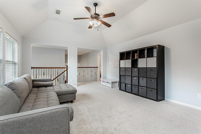 carpeted living room featuring lofted ceiling, a ceiling fan, visible vents, and baseboards