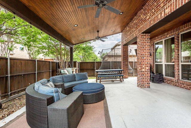 view of patio with a trampoline, a fenced backyard, ceiling fan, and an outdoor living space