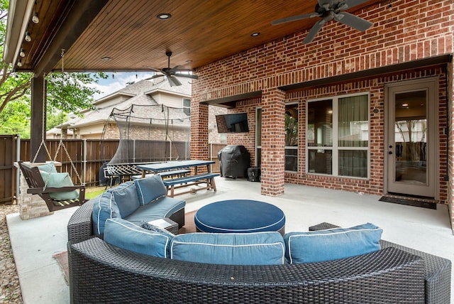 view of patio / terrace with outdoor lounge area, a trampoline, ceiling fan, and fence