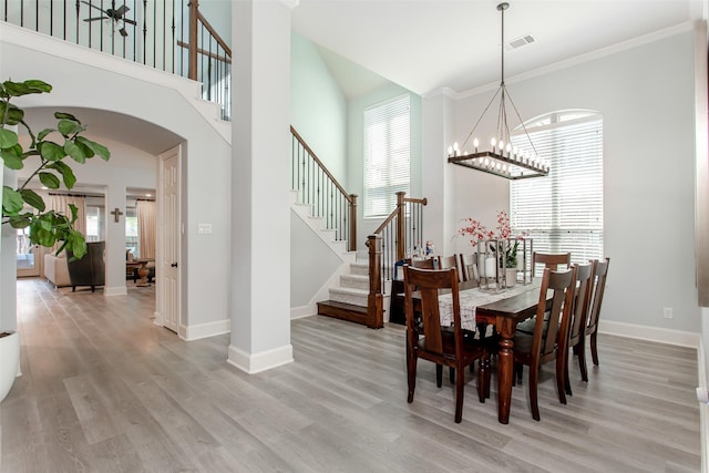 dining area featuring visible vents, light wood finished floors, and a notable chandelier