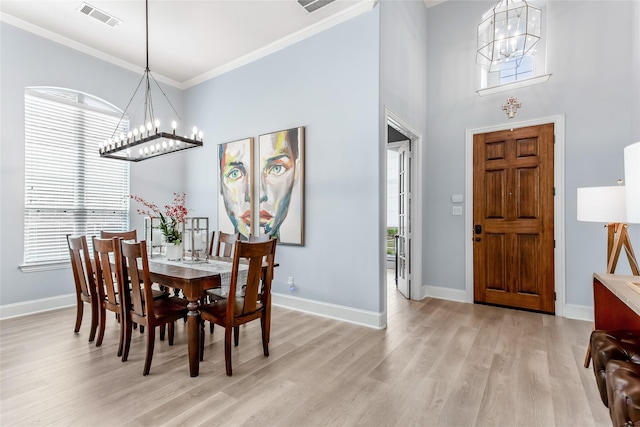 dining area featuring baseboards, an inviting chandelier, visible vents, and light wood-type flooring