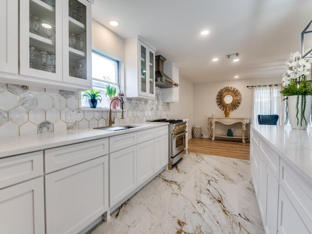 3124 Merrell Rd, Dallas, TX 75229 - kitchen featuring high end stainless steel range, wall chimney exhaust hood, a sink, white cabinetry, and light marble finish flooring