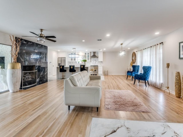 3124 Merrell Rd, Dallas, TX 75229 - living room with a premium fireplace, light wood-style floors, ceiling fan, recessed lighting, and baseboards