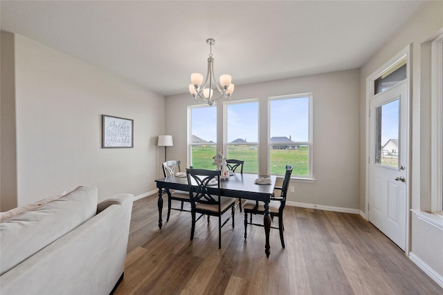 5017 Freestone Dr, Weatherford, TX 76085 - dining space with baseboards, wood finished floors, and an inviting chandelier