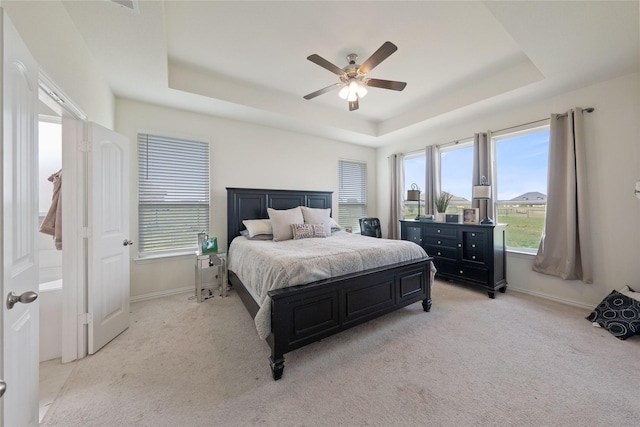 5017 Freestone Dr, Weatherford, TX 76085 - bedroom featuring light colored carpet, baseboards, a raised ceiling, and multiple windows