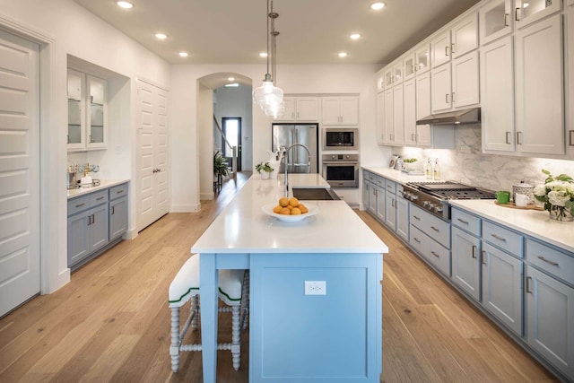 11328 Cider St, Fort Worth, TX 76052 - kitchen featuring appliances with stainless steel finishes, under cabinet range hood, tasteful backsplash, a breakfast bar area, and a sink