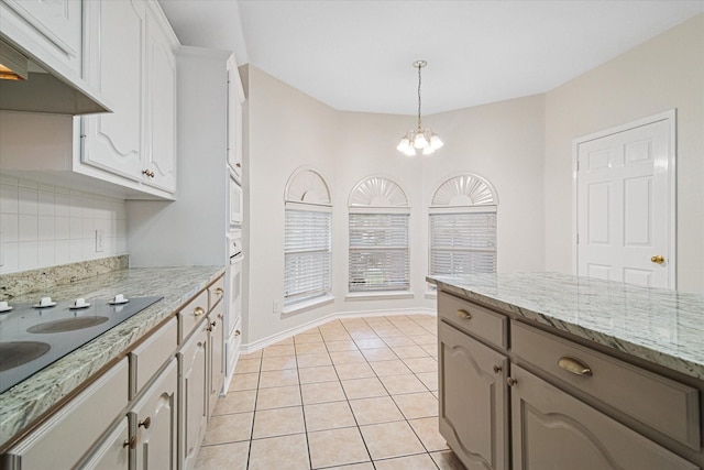 12072 Half Hitch Trl, Frisco, TX 75035 - kitchen featuring light tile patterned floors, an inviting chandelier, tasteful backsplash, under cabinet range hood, and hanging light fixtures