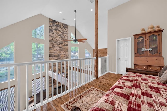 bedroom with high vaulted ceiling and wood finished floors