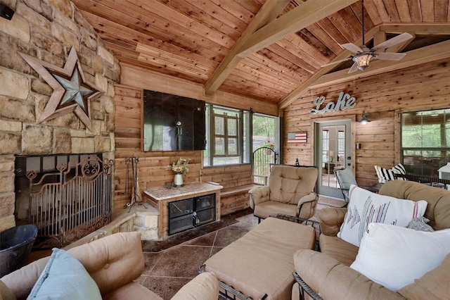 living area featuring wooden walls, wood ceiling, vaulted ceiling with beams, and a ceiling fan