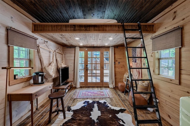 interior space featuring french doors, wood walls, and hardwood / wood-style flooring