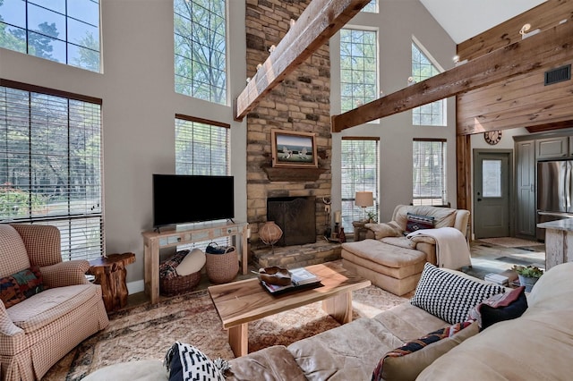living area featuring a stone fireplace and visible vents