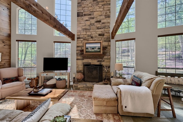 living room with a stone fireplace and a high ceiling