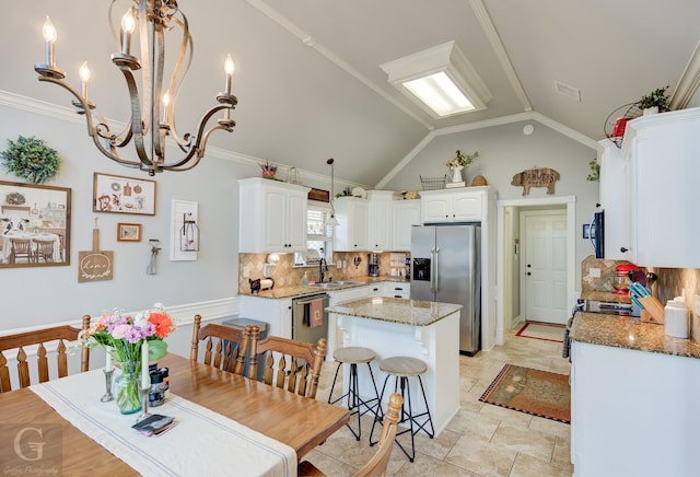5310 Lucerne Ln, Bossier City, LA 71112 - kitchen featuring white cabinets, a center island, vaulted ceiling, and stainless steel appliances