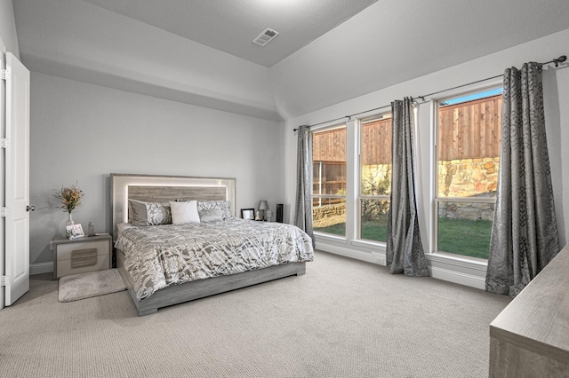 bedroom with vaulted ceiling, carpet flooring, and visible vents