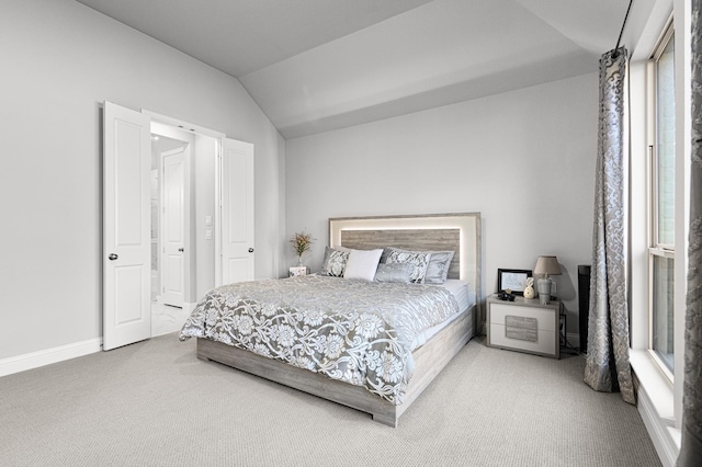 bedroom with carpet floors, baseboards, and lofted ceiling