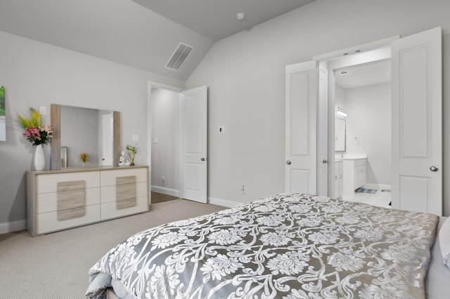 bedroom with light colored carpet, visible vents, vaulted ceiling, baseboards, and ensuite bath