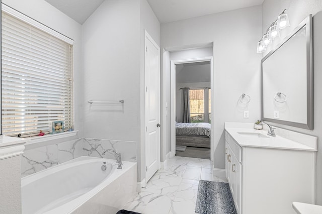 ensuite bathroom featuring vanity, a garden tub, marble finish floor, baseboards, and ensuite bath