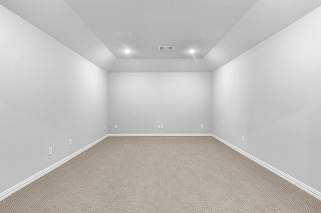 spare room with visible vents, baseboards, lofted ceiling, light carpet, and recessed lighting