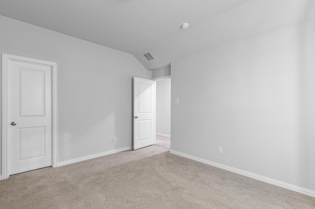 unfurnished bedroom with visible vents, baseboards, carpet floors, and lofted ceiling