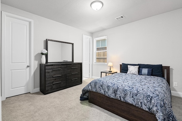 bedroom featuring baseboards, light colored carpet, and visible vents