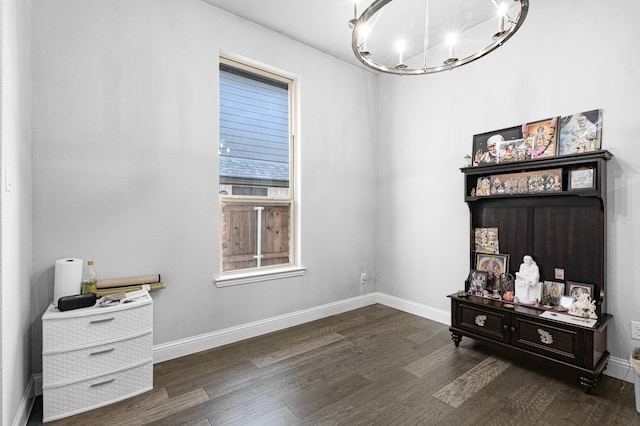 interior space with an inviting chandelier, baseboards, and dark wood finished floors