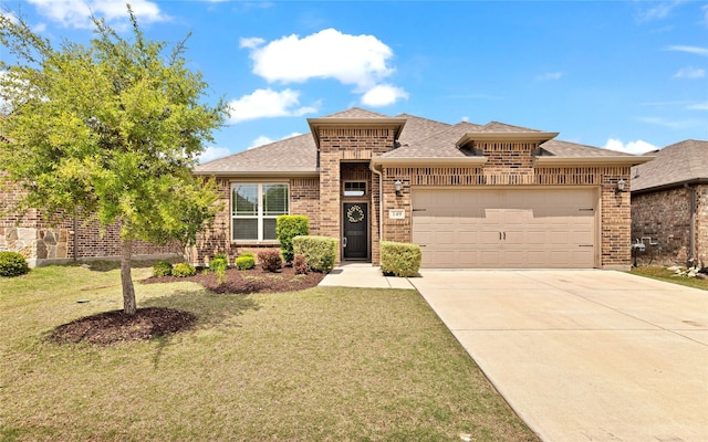 prairie-style home featuring driveway, brick siding, an attached garage, a shingled roof, and a front yard