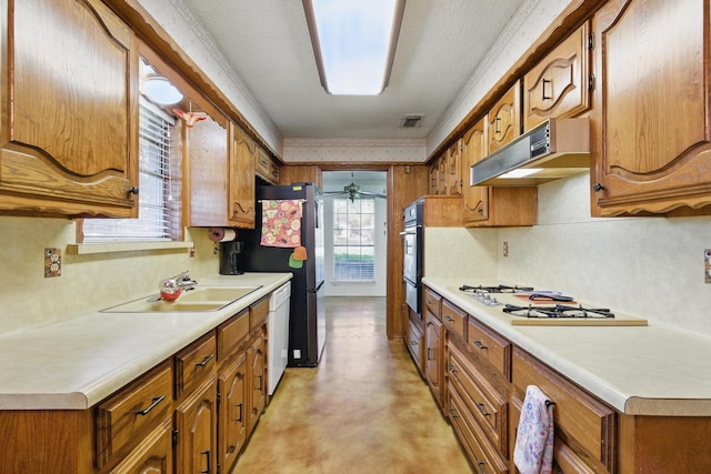 112 Charles St, Desoto, TX 75115 - kitchen featuring brown cabinetry, under cabinet range hood, and white appliances