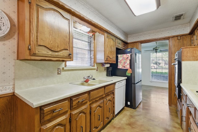 112 Charles St, Desoto, TX 75115 - kitchen with a sink, visible vents, wallpapered walls, white dishwasher, and brown cabinets