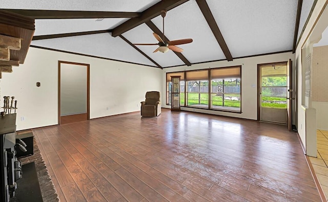 unfurnished living room featuring vaulted ceiling with beams, wood finished floors, a fireplace, and a ceiling fan